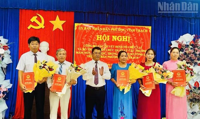 Đồng chí Lê Văn Phương, Chủ tịch Ủy ban nhân dân phường Vĩnh Trạch trao quyết định cho lãnh đạo các trường học trực thuộc phường. (Ảnh lãnh đạo phường cung cấp)