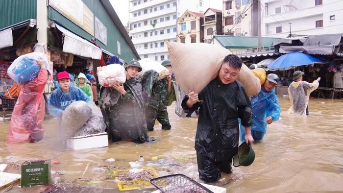 Bộ đội tham gia vận chuyển hàng hóa tại chợ Giếng Vuông. (Ảnh: QSLS)