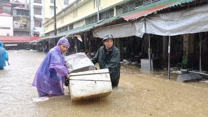Lực lượng bộ đội hỗ trợ người dân di chuyển vật dụng trong mưa bão. (Ảnh : QSLS)