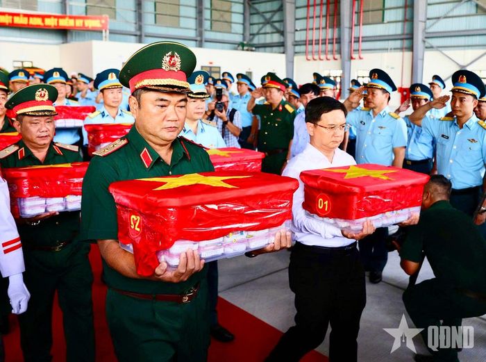 Lãnh đạo Bộ tư lệnh Quân khu 7 và UBND TP Hồ Chí Minh cùng các đại biểu thực hiện nghi thức di chuyển các mẫu hài cốt liệt sĩ lên máy bay. Ảnh: LÊ TIẾN