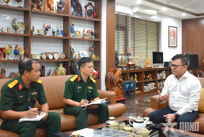Nhà báo Lê Quốc Minh trò chuyện với phóng viên Báo Quân đội nhân dân. Ảnh: LAM HẠ 