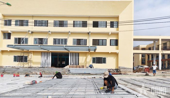 Công nhân hoàn thành một số hạng mục ở nhà đa năng. 