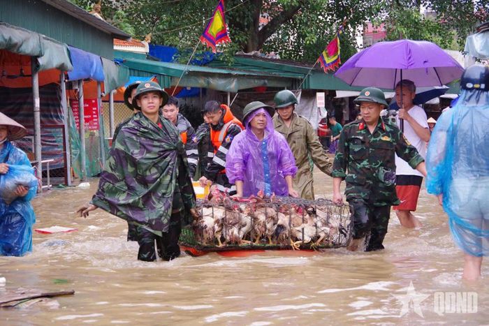 Cán bộ, chiến sĩ giúp các tiểu thương đưa hàng hóa khỏi khu vực ngập lụt.