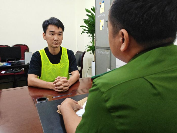  Cán bộ điều tra lấy lời khai của bị can Vũ Hải Long. Ảnh: CACC 