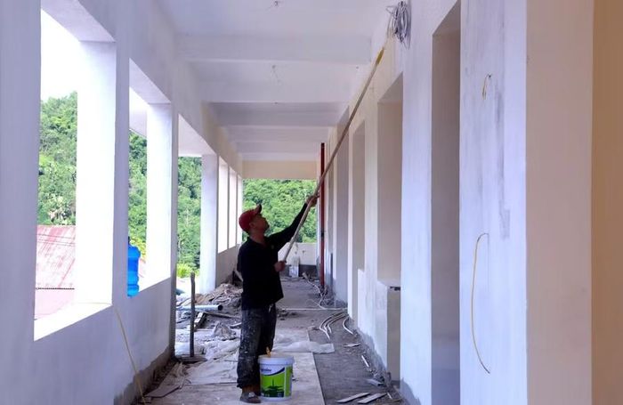 Công nhân sơn tường hành lang khu lớp học Trường Nội trú liên cấp Yên Khương.
