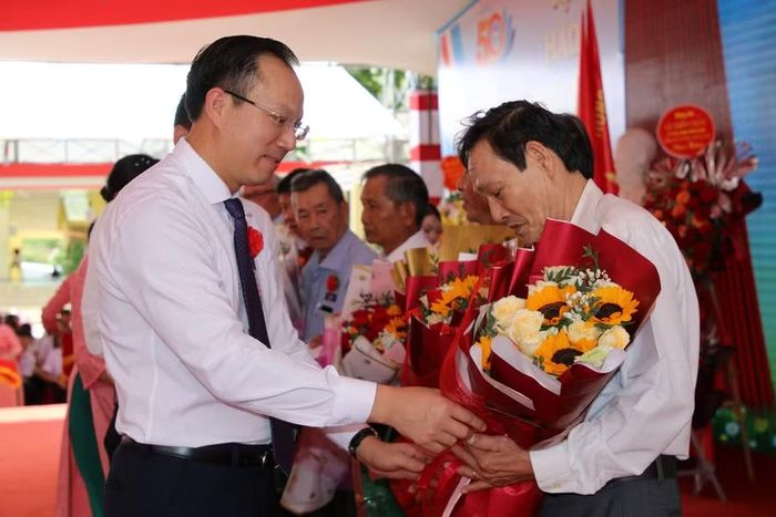 Lãnh đạo Bộ GD&ĐT, UBND tỉnh tặng hoa tri ân thầy cô qua các thời kỳ. (Ảnh: Thế Hùng)