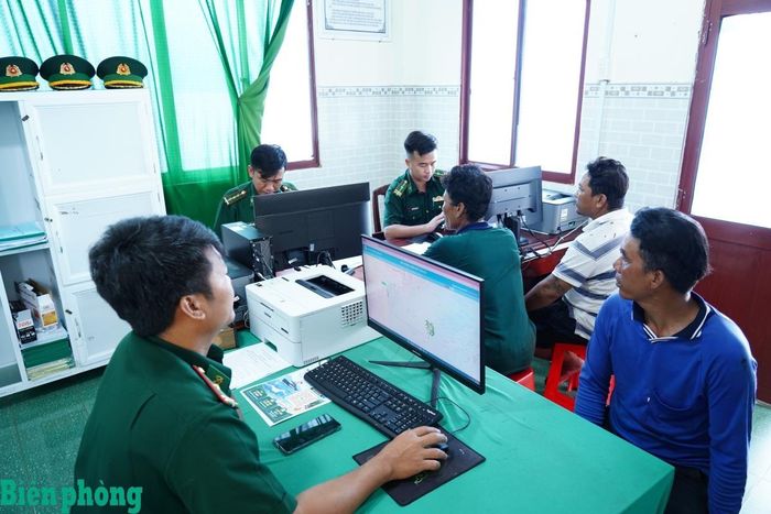 Người dân đến Trạm Kiểm soát Biên phòng Kinh Dài để được cán bộ Biên phòng hướng dẫn cách cài đặt, sử dụng phần mềm quản lý tàu cá trên điện thoại thông minh. Ảnh: Tiến Vinh