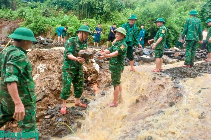 Cán bộ, chiến sĩ Đồn Biên phòng Trung Lý cùng các lực lượng khẩn trương khắc phục điểm sạt lở, bảo đảm an toàn cho người dân và phương tiện qua lại. Ảnh: Biên Cương
