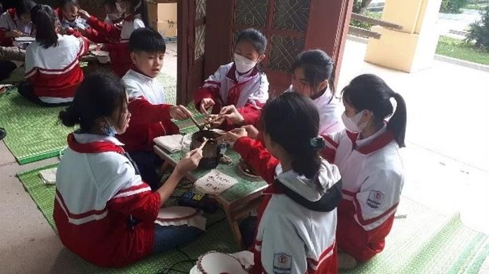 Học sinh trải nghiệm kỹ thuật vẽ hoa văn bằng sáp ong của Indonesia tại Bảo tàng Văn hóa các dân tộc Việt Nam. Ảnh: mcve.org.vn