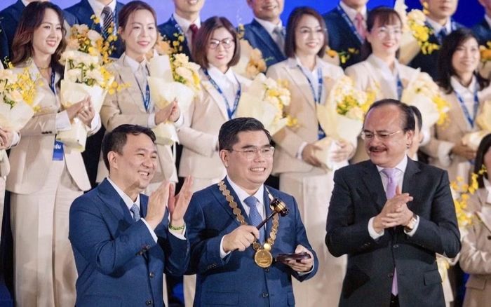 Anh Phan Tấn Đạt (đứng giữa, hàng đầu) nhận nghi thức chuyển giao chức Chủ tịch Hội Doanh nhân trẻ TPHCM từ người tiền nhiệm.