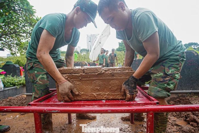 Hài cốt liệt sĩ được các chiến sĩ di chuyển từng phần một cách cẩn trọng, nhẹ nhàng. Mỗi thao tác đều được thực hiện tỉ mỉ để bảo đảm nguyên trạng phục vụ quá trình lấy mẫu.