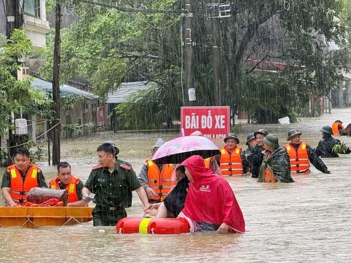 Lực lượng vũ trang lội nước hỗ trợ người dân di dời đến nơi an toàn