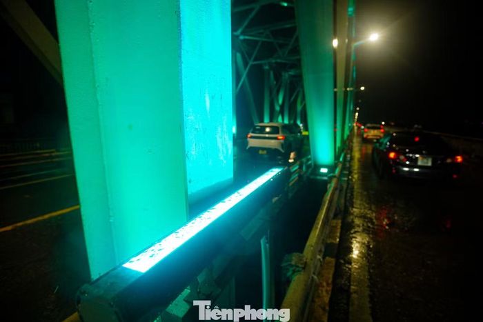Đỏ, xanh lam, xanh lục, tím, vàng... lần lượt phủ lên các nhịp cầu, tạo nên những dải ánh sáng nổi bật vắt ngang sông Hồng.