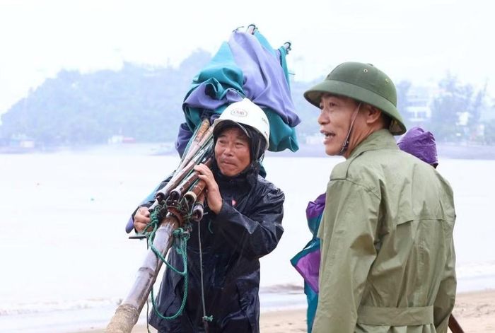 Ngư dân Đồ Sơn thu dọn ô dù tại các ki-ôt kinh doanh dịch vụ du lịch ven các bãi tắm.