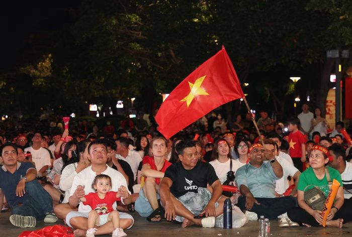 Hòa vào dòng người nô nức cổ vũ cho đội tuyển Việt Nam, các du khách nước ngoài cũng hào hứng đeo băng-rôn, sticker và vẫy cờ cổ động các chiến binh Sao vàng.