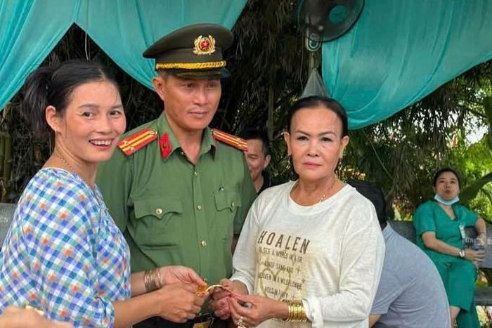 Bà Nguyễn Thị Thu Vân (áo trắng) nhận lại lắc vàng sau khi đánh rơi.