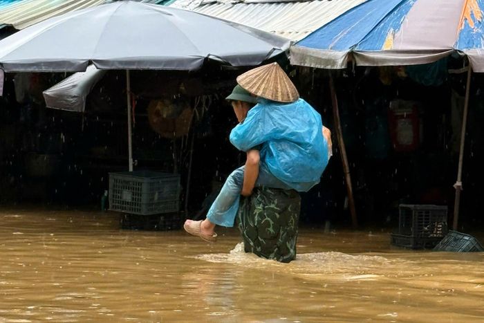 Người dân được hỗ trợ đưa ra khỏi điểm ngập. Ảnh: Đ.X