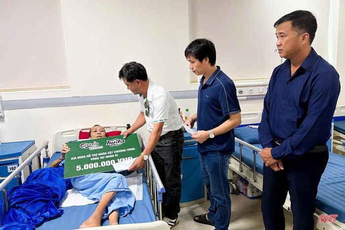 Đại diện Công ty TNHH Carlsberg Việt Nam – Nhãn hàng Bia Huda trao phần quà hỗ trợ cho anh Bùi Văn Trung.