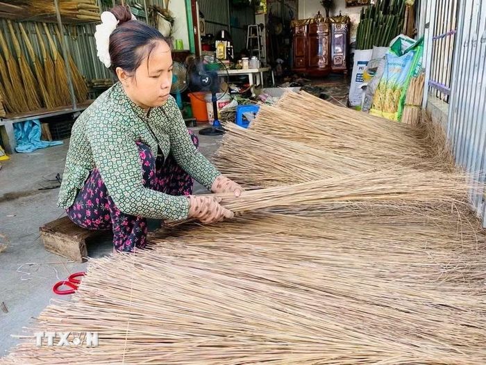 Người thợ lựa chọn, sắp xếp những nan dừa phù hợp trước khi bó thành chổi. (Ảnh: Thanh Sang/TTXVN)