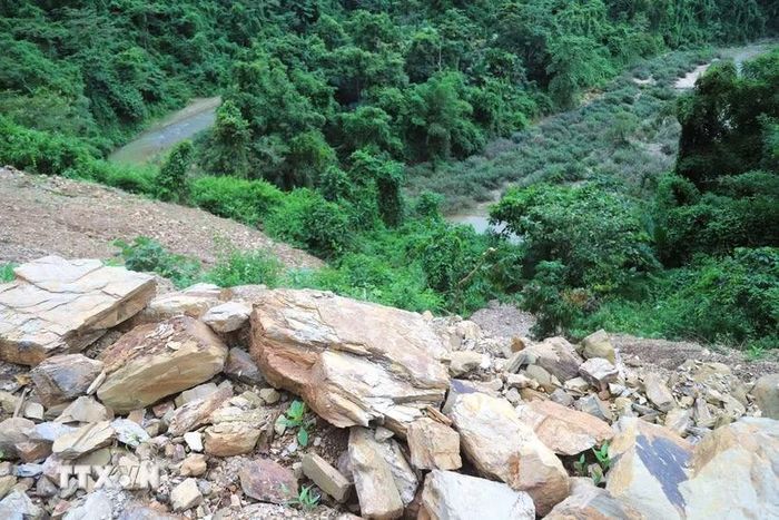Lượng lớn đất, đá sau những vụ sạt lở còn nằm bên mép đường ngay sát vách vực taluy âm của suối Nậm Ngân. (Ảnh: Xuân Tiến/TTXVN)