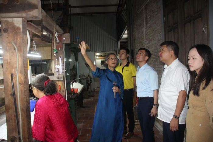 Giám đốc Sở Khoa học và Công nghệ Hà Nội Cù Ngọc Trang thăm làng nghề Vạn Phúc và nghe các nghệ nhân giới thiệu về nghề dệt. (Ảnh: Sở Khoa học và Công nghệ Hà Nội)