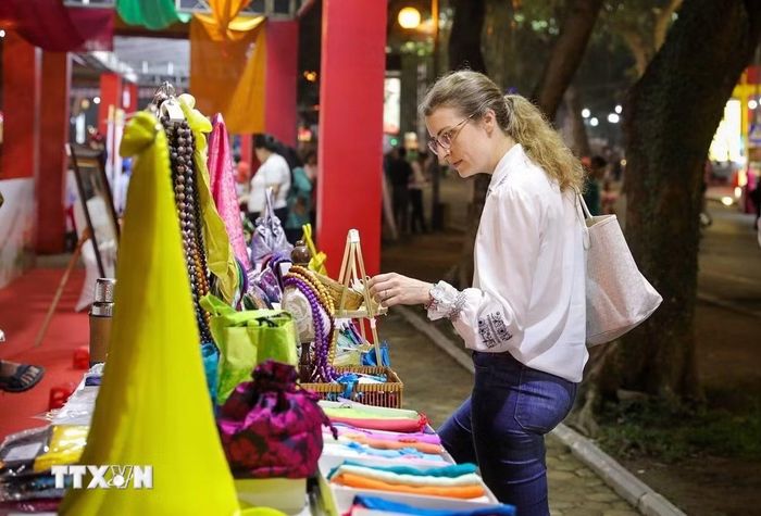 Du khách nước ngoài tham quan các sản phẩm tại gian trưng bày của làng lụa Vạn Phúc. (Ảnh: Khánh Hòa/TTXVN)