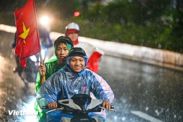 Có những gia đình cùng nhau xuống phố, có nhóm bạn trẻ khoác vai nhau vừa đi vừa hát, trong khi nhiều người tranh thủ ghi lại khoảnh khắc đáng nhớ bằng điện thoại. (Ảnh: Minh Sơn/Vietnam+)