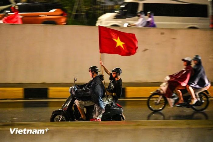 Khu vực Hầm Kim Liên - Đại Cồ Việt hàng nghìn người cầm cờ reo hò sau chiến thắng của đội tuyển Việt Nam. (Ảnh: Minh Sơn/Vietnam+)