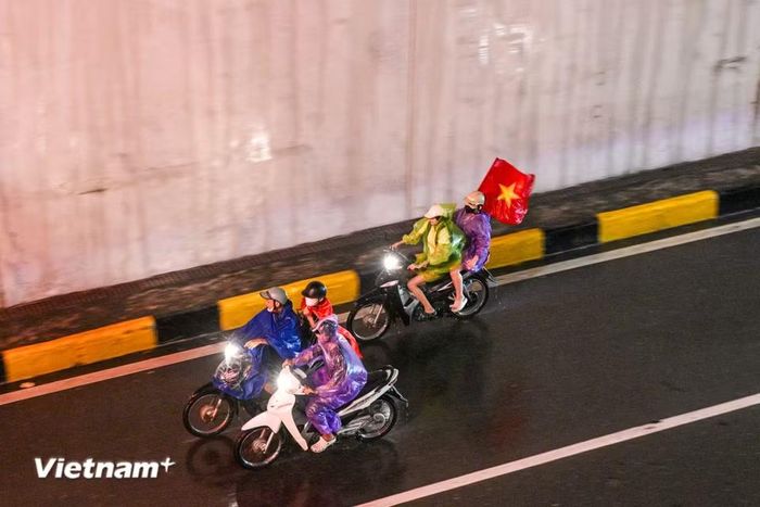 Những cơn mưa bất chợt không thể ngăn bước chân người hâm mộ. (Ảnh: Minh Sơn/Vietnam+)