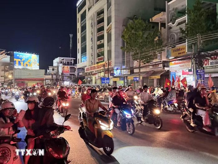 Người hâm mộ bóng đá An Giang xuống đường ăn mừng chiến thắng cùng đội tuyển Việt Nam. (Ảnh: Thanh Sang/TTXVN)
