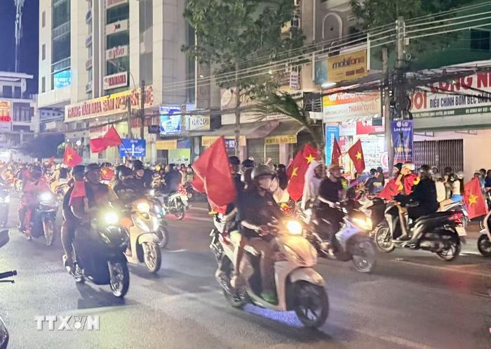 Người hâm mộ bóng đá An Giang mang cờ Tổ quốc xuống đường chia vui chiến thắng cùng đội tuyển Việt Nam. (Ảnh: Thanh Sang/TTXVN)