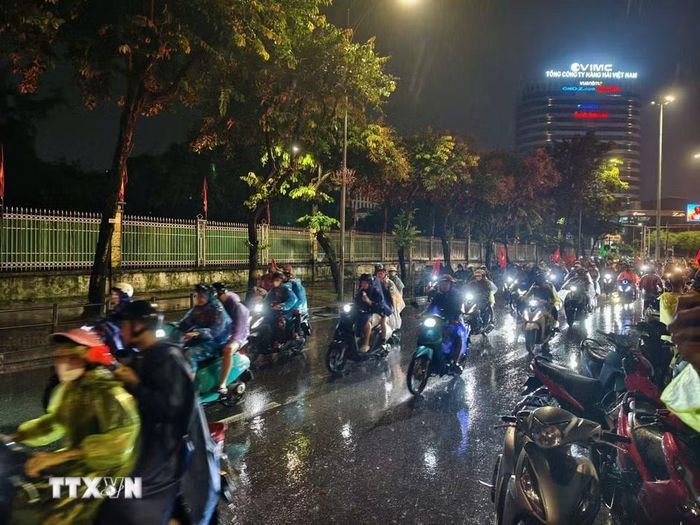 Cơn mưa xuyên suốt cả ngày không ngăn được niềm vui của người hâm mộ Thủ đô. (Ảnh: Minh Quyết/TTXVN)