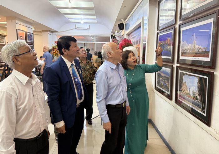 Đại biểu và khách mời nghe giới thiệu về các tác phẩm nhiếp ảnh được trưng bày.