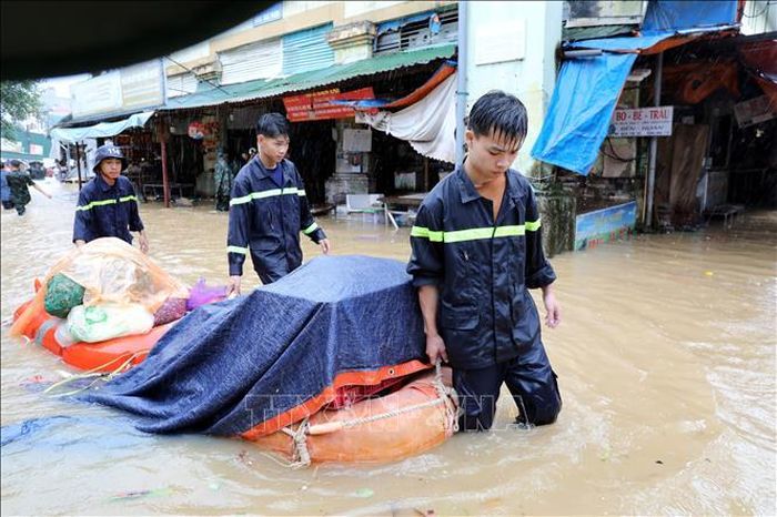 Cán bộ chiến sĩ lực lượng vũ trang tỉnh Lạng Sơn hỗ trợ tiểu thương di chuyển tài sản ra khỏi khu vực ngập sâu.