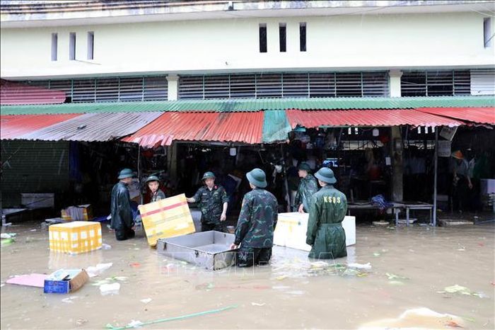 Cán bộ chiến sĩ Bộ Chỉ huy Quân sự tỉnh Lạng Sơn giúp tiểu thương di chuyển tài sản ra khỏi khu vực ngập sâu.