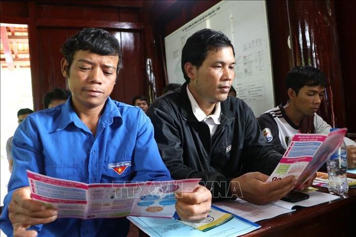 Đồng bào dân tộc thiểu số tìm hiểu chính sách trợ giúp pháp lý qua tờ rơi. Ảnh: Đinh Hương/TTXVN
