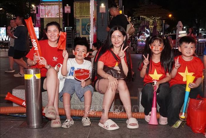 Các gia đình đưa con nhỏ đến phố đi bộ Nguyễn Huệ để cùng hòa mình vào không khí cổ vũ đội tuyển Việt Nam trong trận chung kết lượt đi ASEAN Hyundai Cup 2026 gặp Thái Lan.