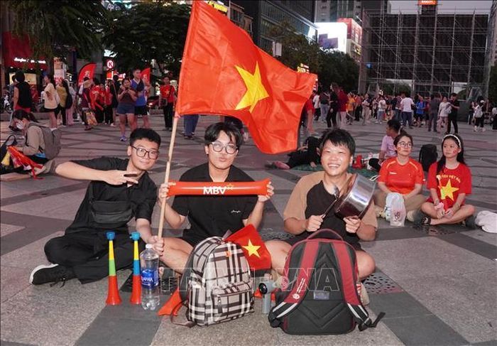 Các bạn trẻ mang theo cờ Tổ quốc, kèn và dụng cụ cổ vũ, có mặt từ sớm tại phố đi bộ Nguyễn Huệ để tiếp lửa đội tuyển Việt Nam trước trận chung kết lượt đi ASEAN Hyundai Cup 2026 gặp Thái Lan.