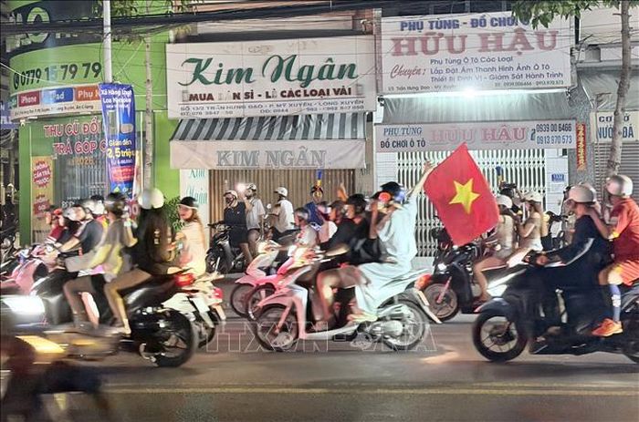 Người hâm mộ bóng đá An Giang mang cờ Tổ quốc xuống đường chia vui chiến thắng cùng đội tuyển Việt Nam.