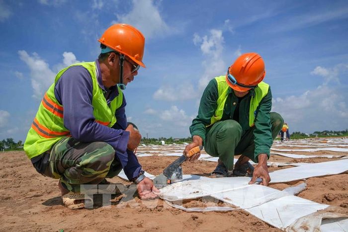 Công nhân trải vật liệu xử lý, gia cố nền đất yếu tại gói thầu số 1, dự án thành phần 2 cao tốc Châu Đốc - Cần Thơ - Sóc Trăng, đoạn giáp ranh tỉnh An Giang ngày 22/8/2026. Ảnh: Thanh Liêm - TTXVN