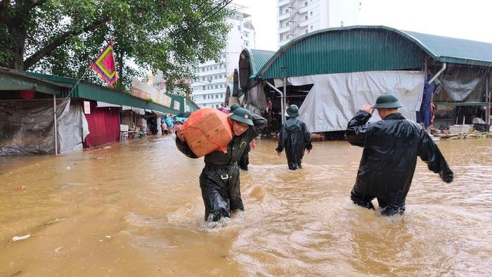 Bộ đội Lạng Sơn sơ tán hàng hóa trong chợ Giếng Vuông đến nơi an toàn. Ảnh: Dương Nguyên. 