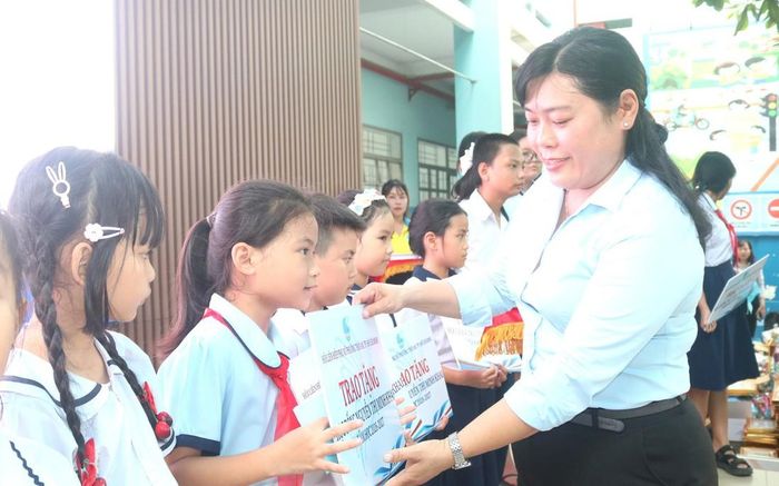 Bà Nguyễn Thị Nhung, Chủ tịch Ủy ban MTTQ Việt Nam phường Thới An, TPHCM trao bảng tượng trưng tặng học bổng Nguyễn Thị Minh Khai, năm học 2026 – 2027 đến các em.
