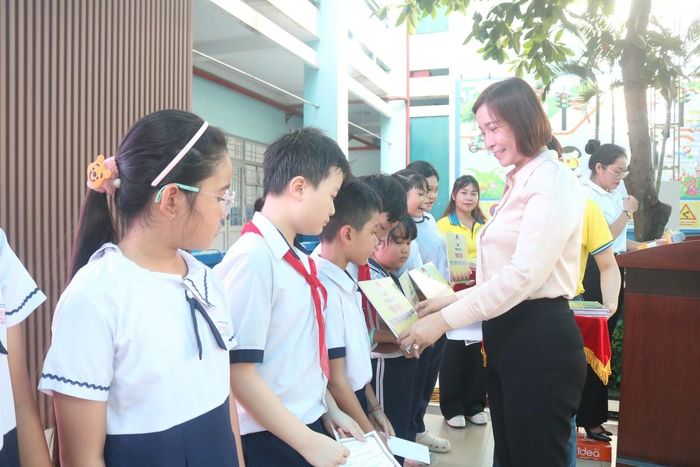 Bà Đặng Thị Kiều Nhi, Phó bí thư thường trực Đảng ủy phường Thới An, TPHCM trao bảng tượng trưng học bổng Nguyễn Hữu Thọ, năm học 2026 – 2027 đến các em học sinh.