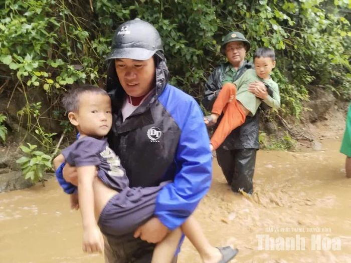 Cán bộ Đồn biên phòng Tam Chung hỗ trợ bà con bản Suối Lóng di dời đến nơi an toàn.