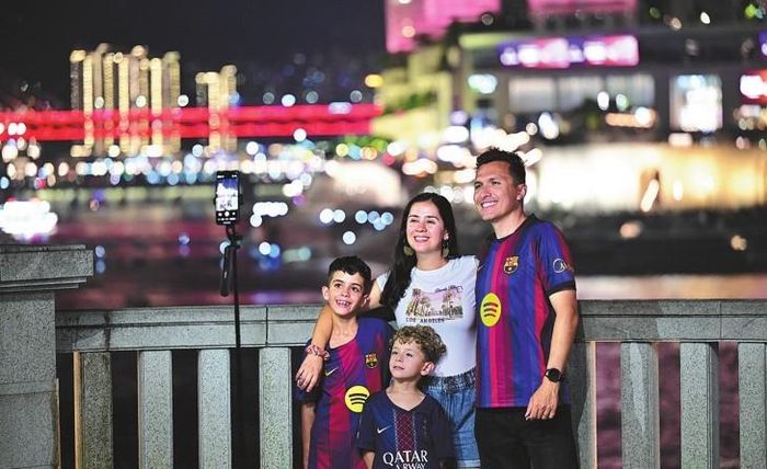 Du khách nước ngoài chụp ảnh selfie tại quận Nan'an, Trùng Khánh. Ảnh: GUO XU/XINHUA