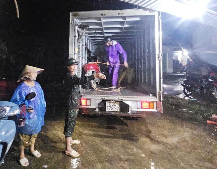 Lực lượng chức năng xã Sơn Động giúp người dân di dời tài sản trong đêm.