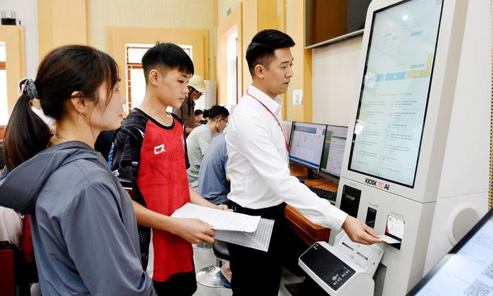  Anh Lương Văn Huy hỗ trợ người dân thực hiện thủ tục hành chính trực tuyến trên Kiosk AI tại Trung tâm Phục vụ hành chính công phường Bắc Giang. 