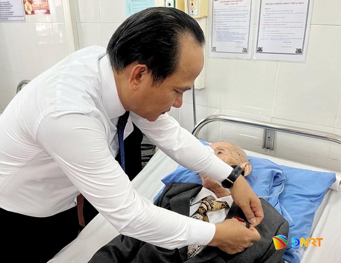 Chủ tịch Ủy ban MTTQ Việt Nam thành phố Nguyễn Đình Vĩnh gắn Huy hiệu 80 năm tuổi Đảng cho ông Võ Minh Châu. Ảnh: AN KHÊ