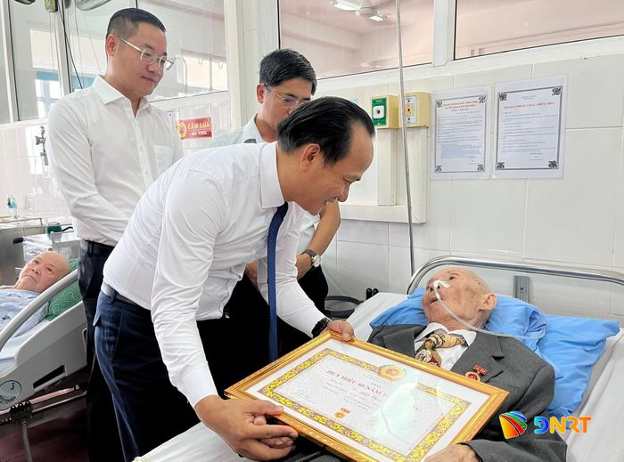 Chủ tịch Ủy ban MTTQ Việt Nam thành phố Nguyễn Đình Vĩnh trao Huy hiệu 80 năm tuổi Đảng và ân cần thăm hỏi, động viên đảng viên Võ Minh Châu luôn mạnh khỏe. Ảnh: AN KHÊ