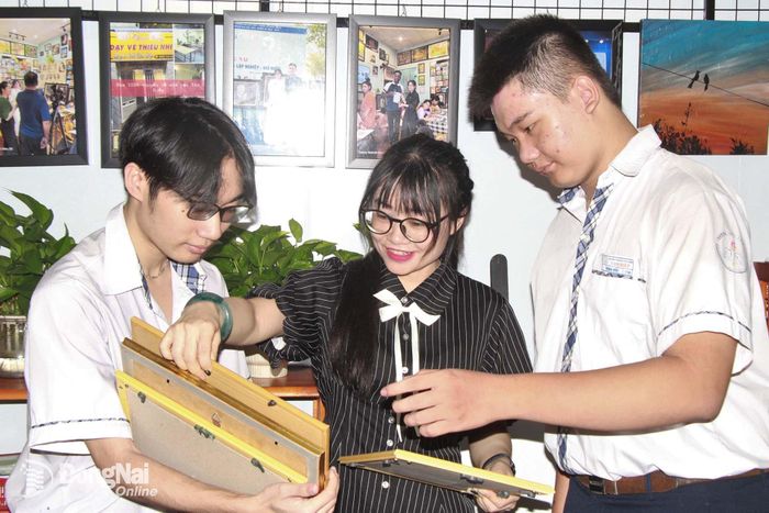 Chị Lê Thị Hải Hiếu hướng dẫn nhóm học sinh Trường THPT Tam Hiệp lựa chọn các sản phẩm mỹ thuật được làm giấy từ bã mía để chuẩn bị trưng bày, giới thiệu tại workshop.